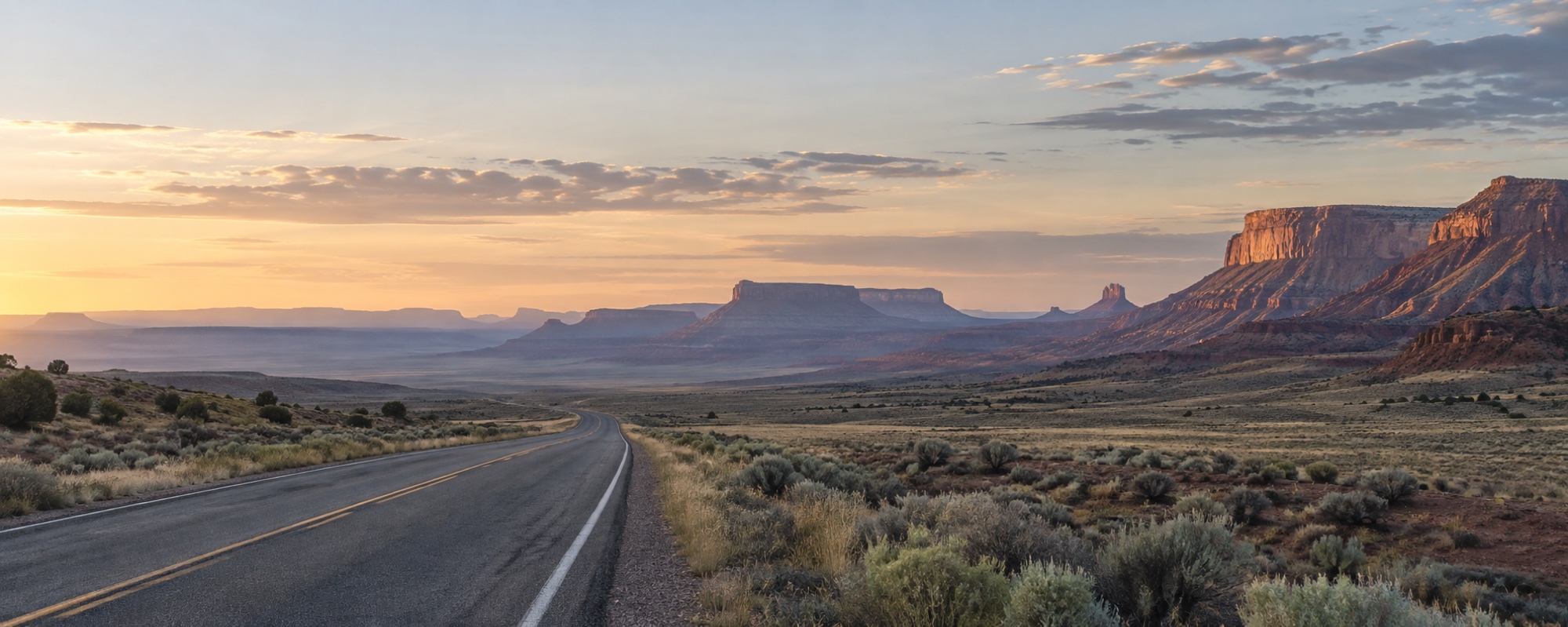 A quiet road crossing the high desert at sunrise